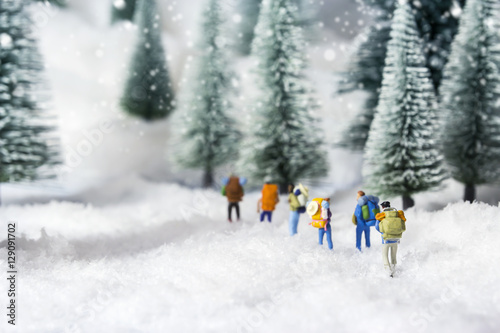 Quadro su tela Miniature backpackers walking in pine forest during winter