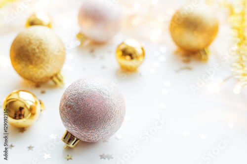 Christmas and New Year background with golden decorative balls for Christmas tree with light bulbs and confetti. Place for text.