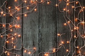 Christmas lights dark frame on grey wooden background