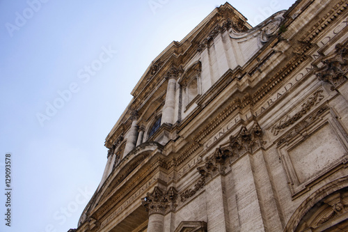 Bottom view of a historical building in Rome with clear blue sky in the background.
