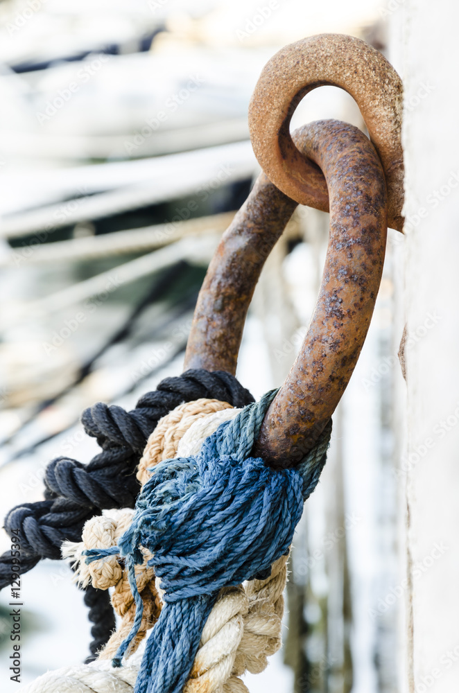 knot and ropes, details of coloured ropes knotted to a rusted metal ring knot and ropes, details of coloured ropes knotted to a rusted metal ring