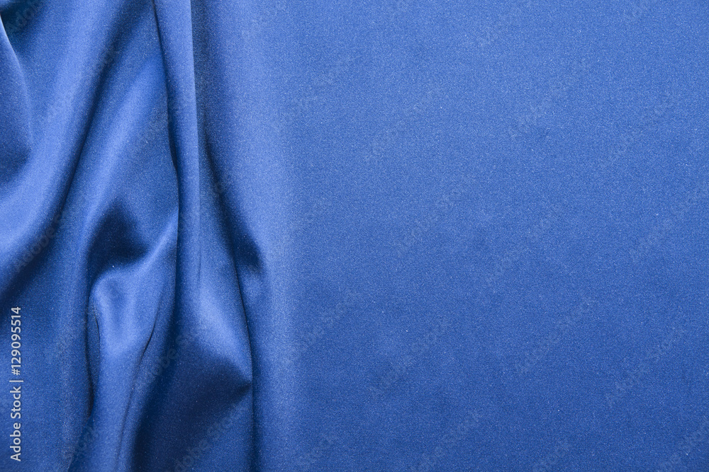 Fototapeta premium Blue silk background. Abstract wavy texture