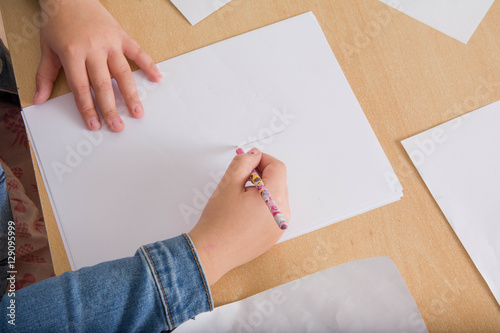 Hand of a child drawing on white paper