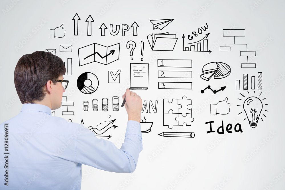 Businessman in blue shirt is drawing a startup idea sketch on a Businessman in blue shirt is drawing a startup idea sketch on a