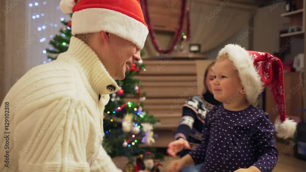 Young happy couple kidding with their daughter at Christmas Young happy couple kidding with their daughter at Christmas