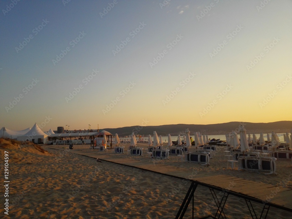 Obraz premium Beach in sunrise with beach chairs and umbrellas (Bulgaria, Sunny Beach)