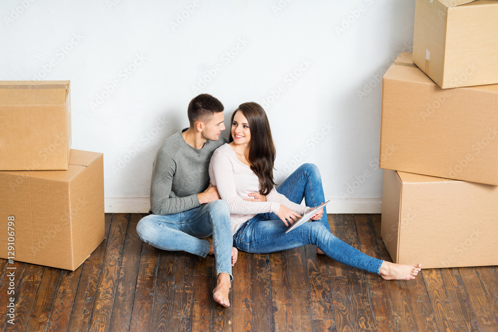Young couple unboxing in their new home Young couple unboxing in their new home