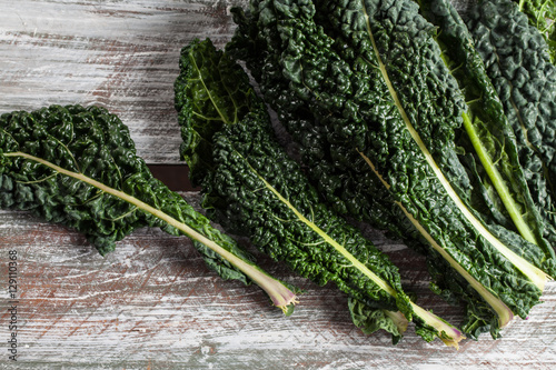 Above shot of organic lacinato kale on brown wood table above shot