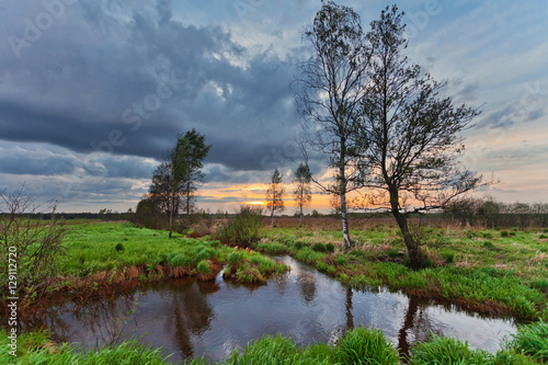 Summer sunset around field and river