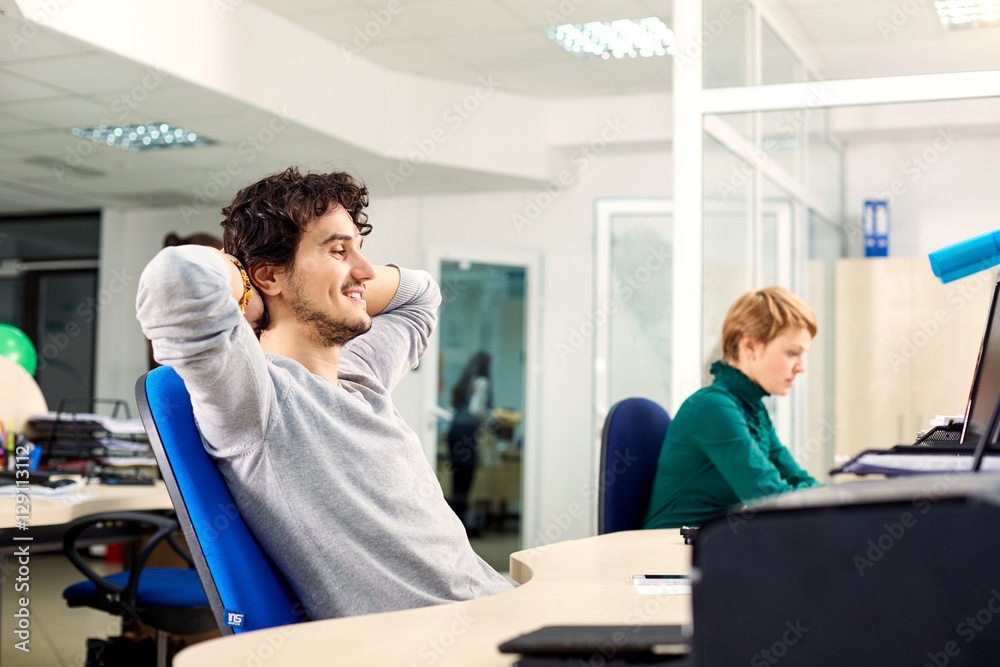 Successful businessman sitting pretty at the table in office, dreaming, resting on job Successful businessman sitting pretty at the table in office, dreaming, resting on job