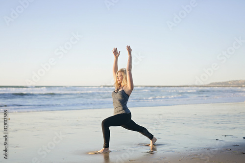 Woman does yoga on the beach