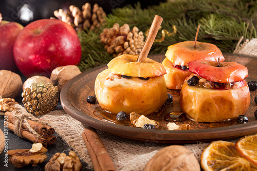 Baked apples on brown plate with holiday Christmas decoration photo