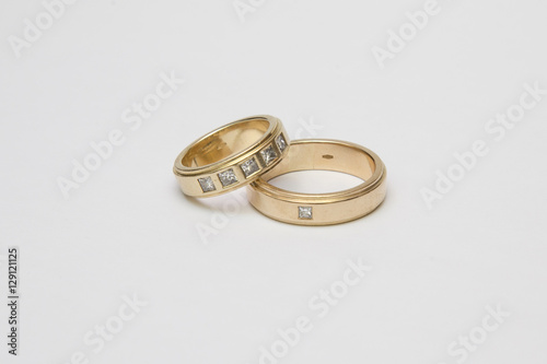 Yellow gold wedding rings with diamonds isolated on white