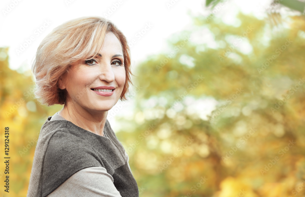 Beautiful middle aged woman in autumn park