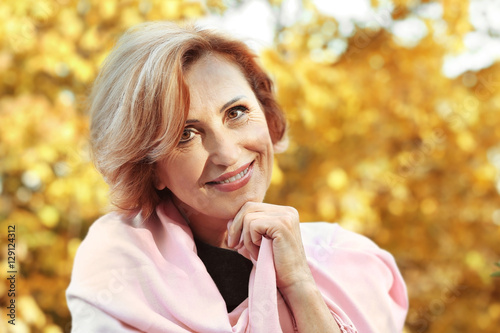 Closeup portrait of gorgeous middle aged woman in autumn park