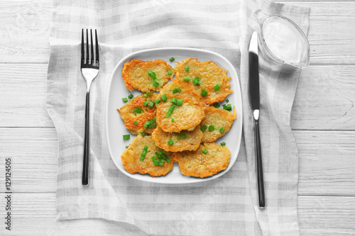 Plate with tasty potato pancakes for Hanukkah on wooden table
