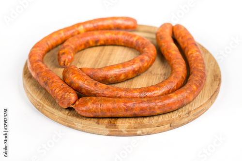 Raw homemade domestic sausage on the wooden board. Isolated over
