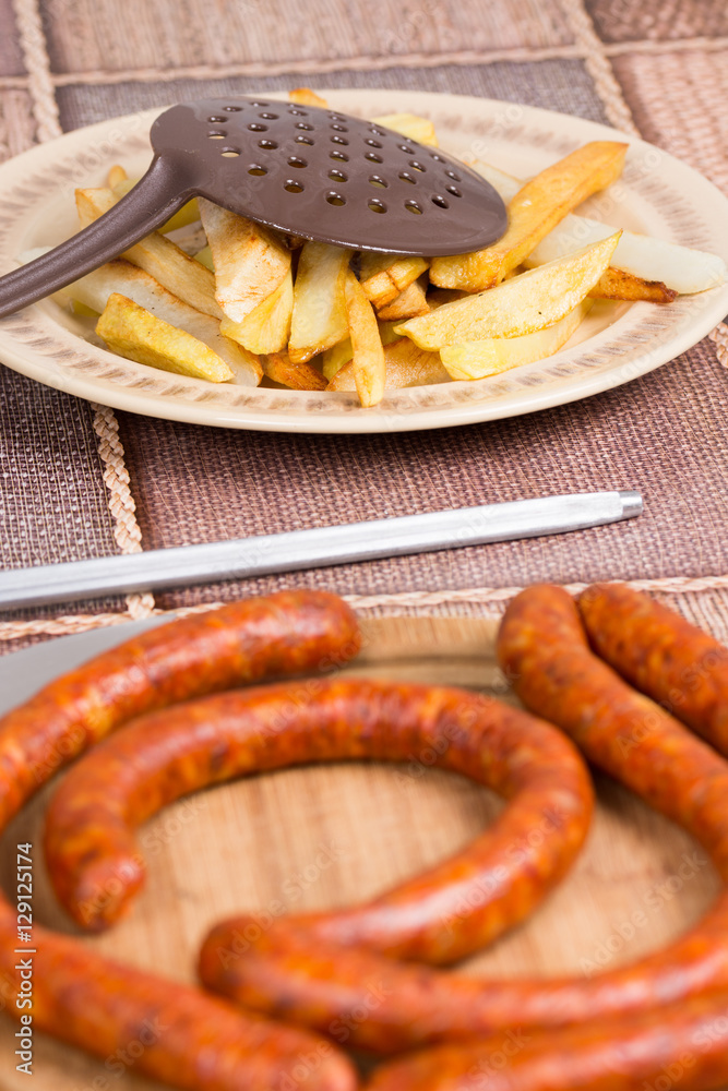 Raw domestic red sausages with fried potatoes Raw domestic red sausages with fried potatoes