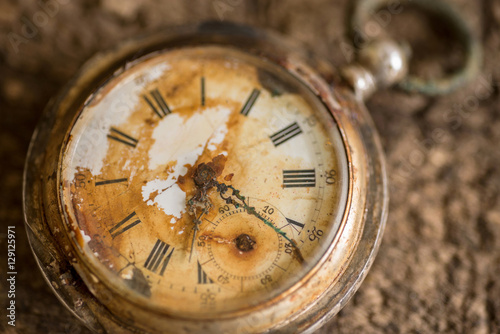 Antique silver broken pocket watch on wooden background.