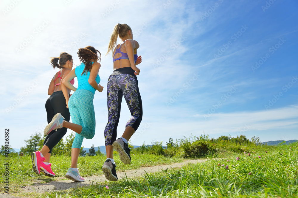 Three Female Joggers running together outdoors Three Female Joggers running together outdoors