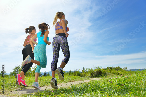 Three Female Joggers running together outdoors