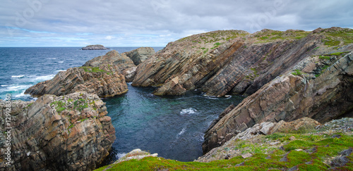 Cape Bonavista featuring coastal slabs of stone boulders and rocks that show their layers of formation over millions of years. Rocky boulder shoreline in Newfoundland, Canada.
