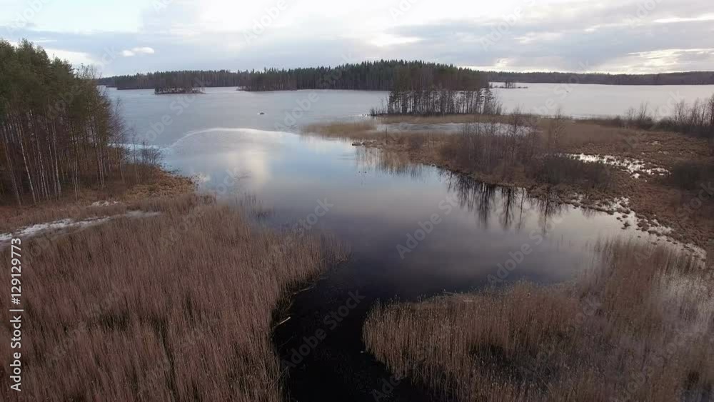 Backwards overflight of a small river leading to a lake in spring Backwards overflight of a small river leading to a lake in spring