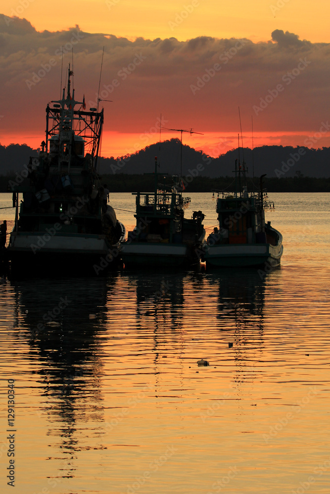 Fishing boats in port at sunset