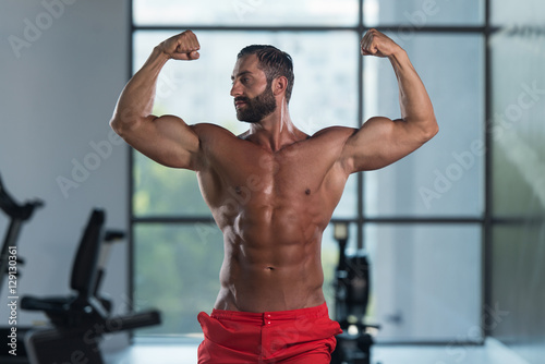 Bodybuilder Flexing Front Double Biceps Pose In Gym