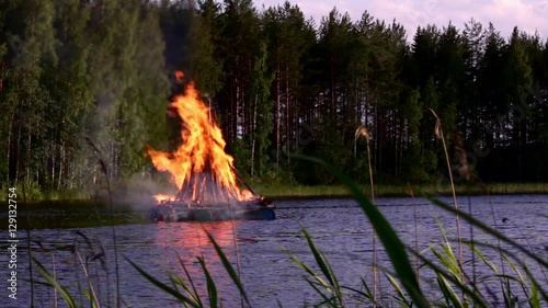 Midsummer pyre burning at a lake in Finland on Midsummer Eve
