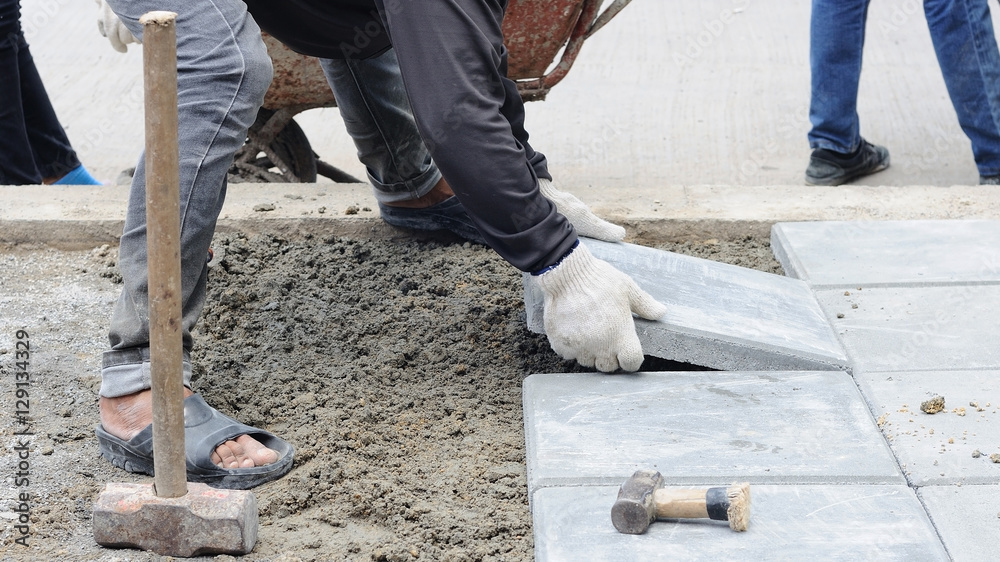 Industrial Worker on placement of the brick in sidewalk.