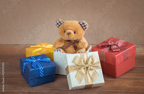Teddy bear in gift box on wooden background
