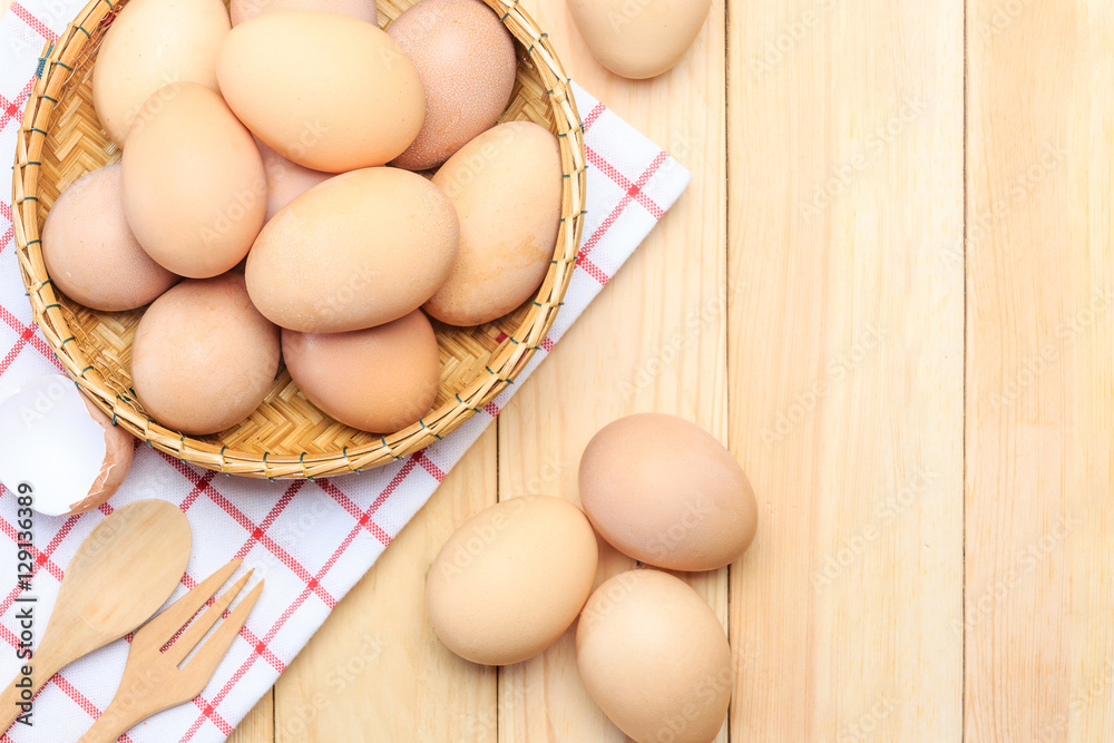 Fresh egg in the basket weaving over wooden table background, Top view with copy space and text. Fresh egg in the basket weaving over wooden table background, Top view with copy space and text.