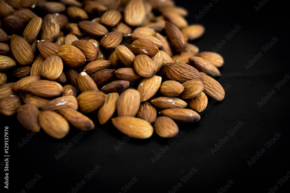 close up almonds nuts on black background close up almonds nuts on black background