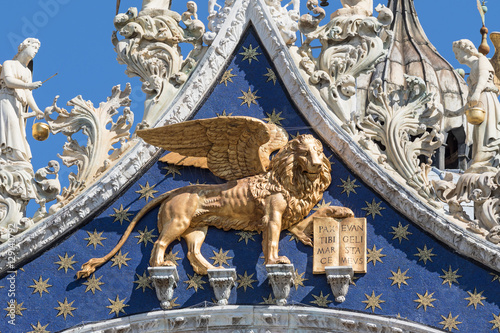 Closeup view of winged golden lion statue on the roof of the Cathedral of San Marco (Venice, Italy). Vertically. 