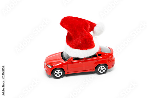 Red toy car in a New Year's cap on a white background