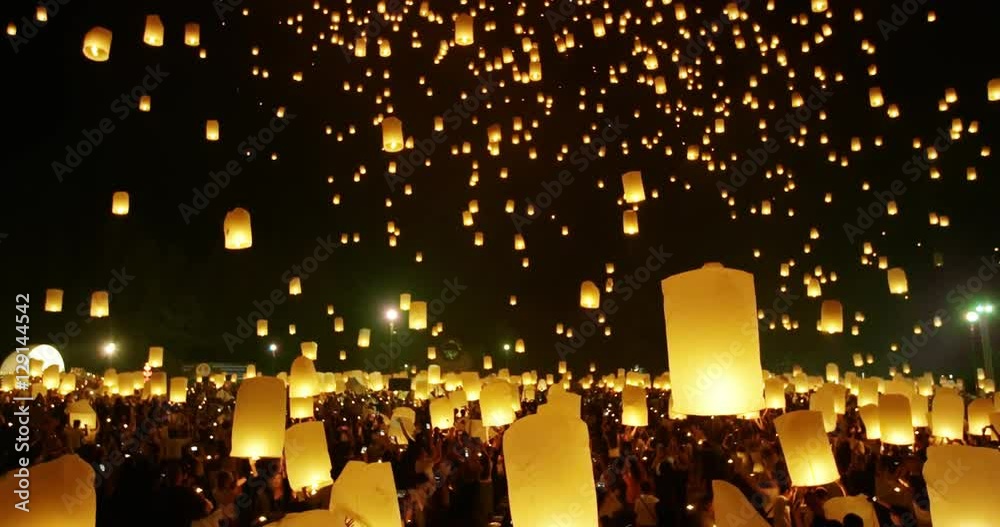 Thousands of sky lanterns floating into night sky at religious festival in Thailand