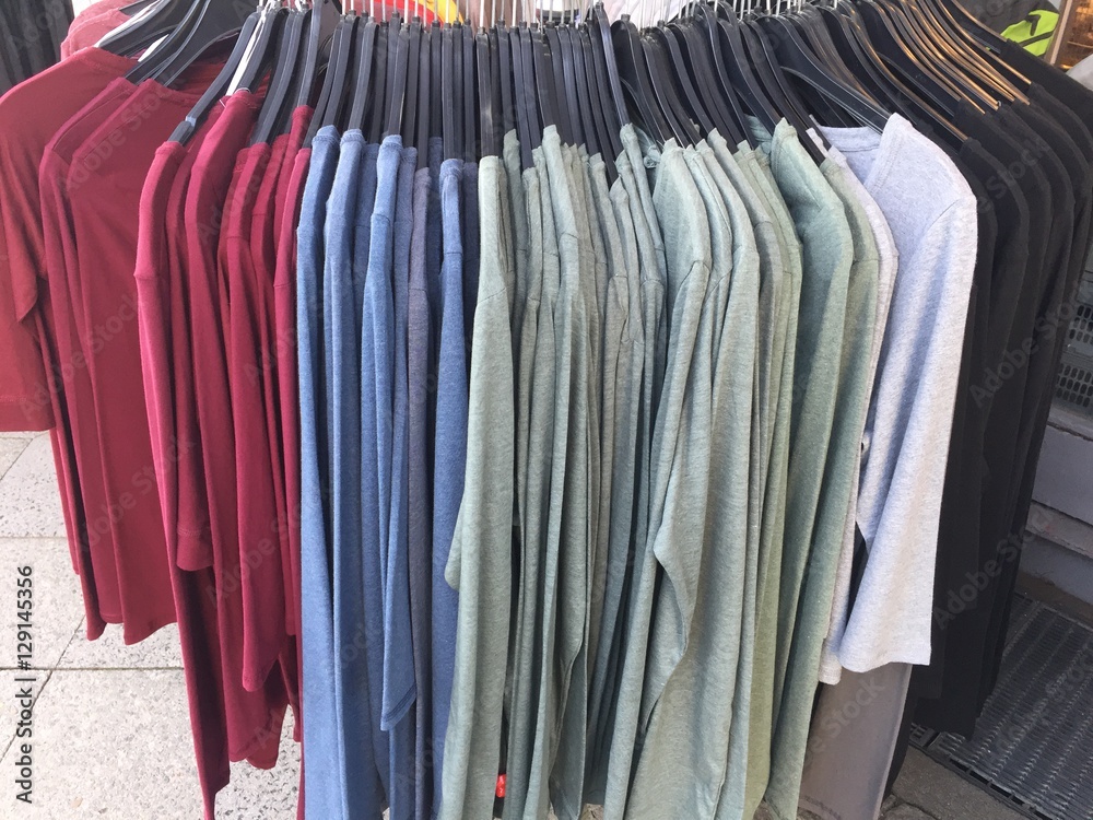Row of colorful t-shirts on rack in store