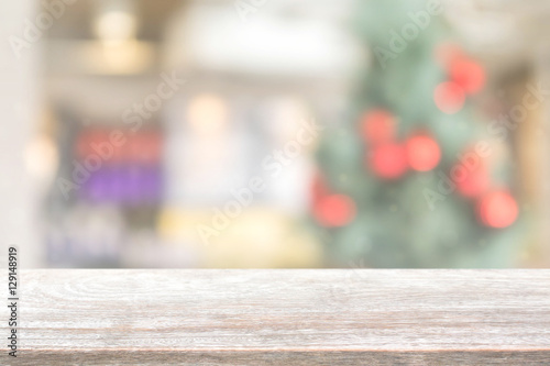 Wood table top on blur with bokeh christmas tree background with vintage filter - can be used for display or montage your products