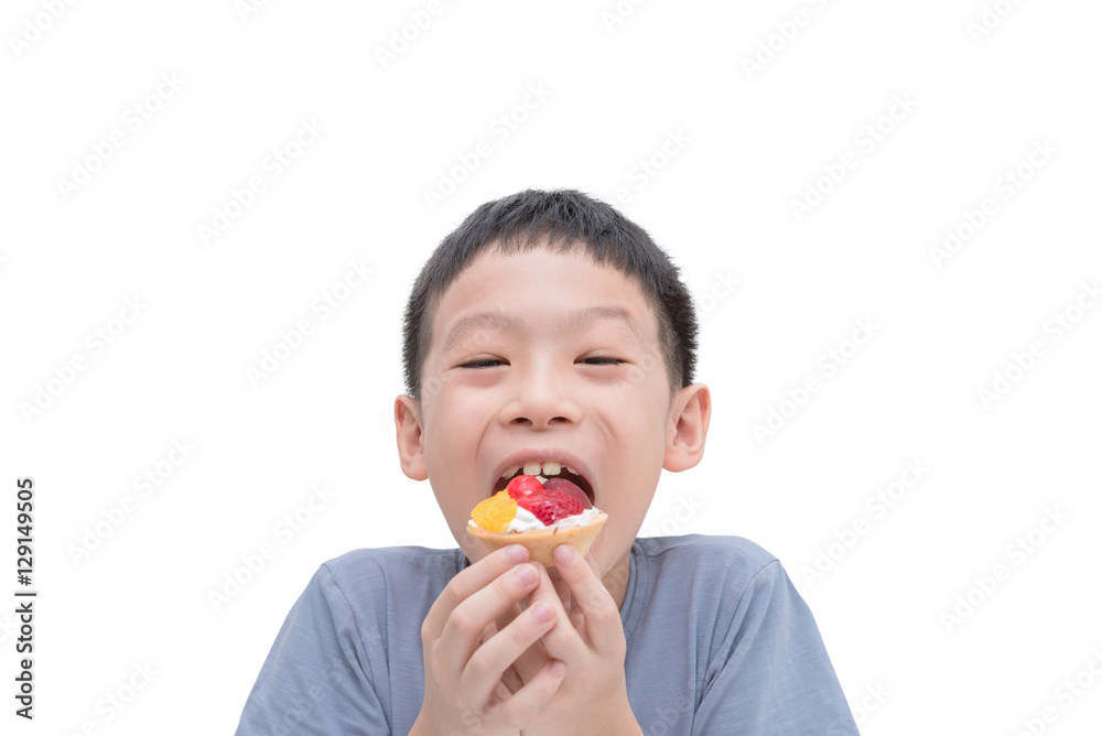 Young Asian boy eating fruit tart over white background Young Asian boy eating fruit tart over white background