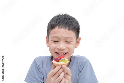 Young Asian boy eating fruit tart over white background