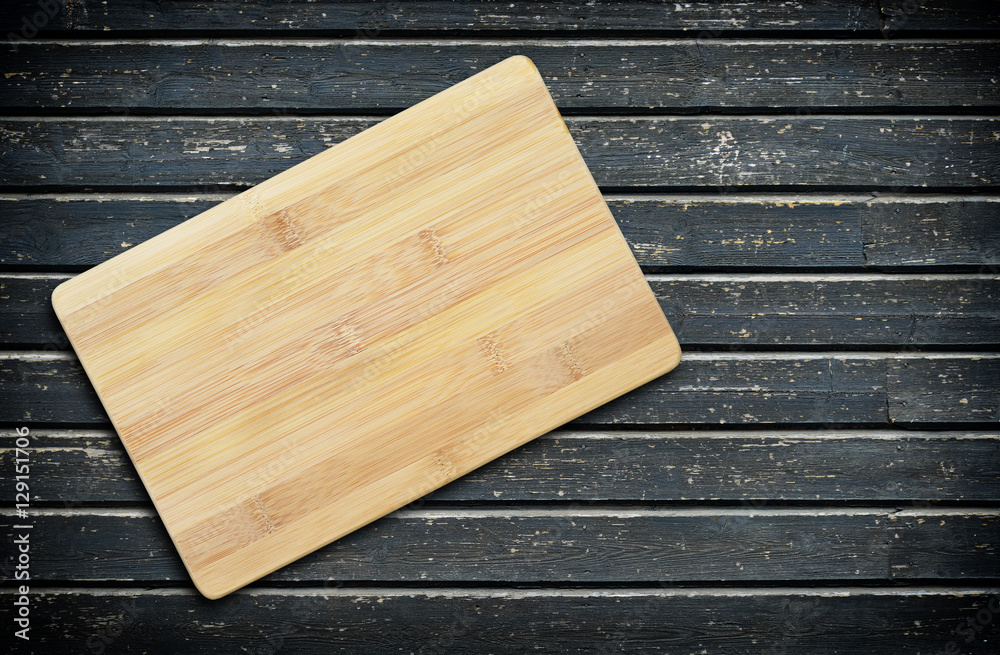 Empty bamboo cutting board on a old wooden table for product display.Top view