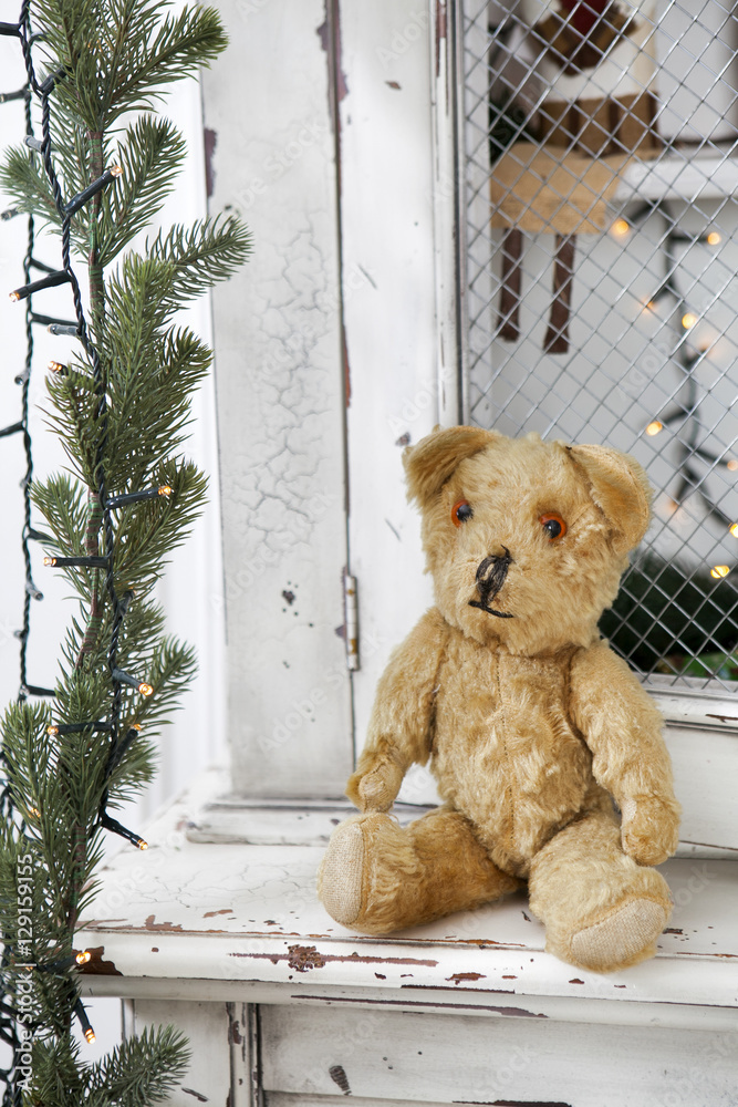 Vintage teddy-bear sitting on the wardrobe