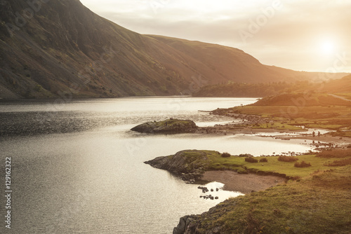 Beautiful sunset landscape image of Wast Water and mountains in photo