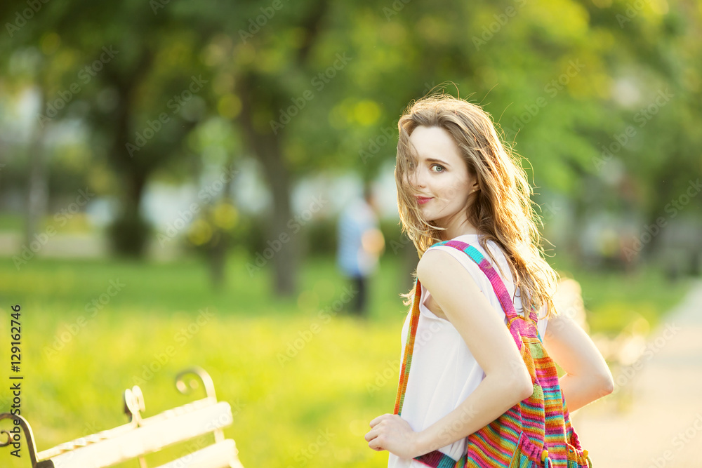 Naklejka premium Fashionable blonde girl walking in a city park