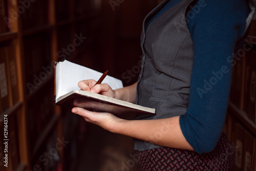Close up of female hands making notes in notebook