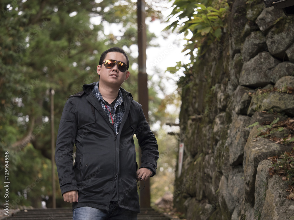 a man relaxing with a beautiful Japan , Nikko autumn tree . focus on the model . Japan autumn set a man relaxing with a beautiful Japan , Nikko autumn tree . focus on the model . Japan autumn set