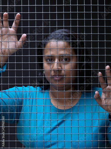 Black woman, behind a steel mesh © fresnel6