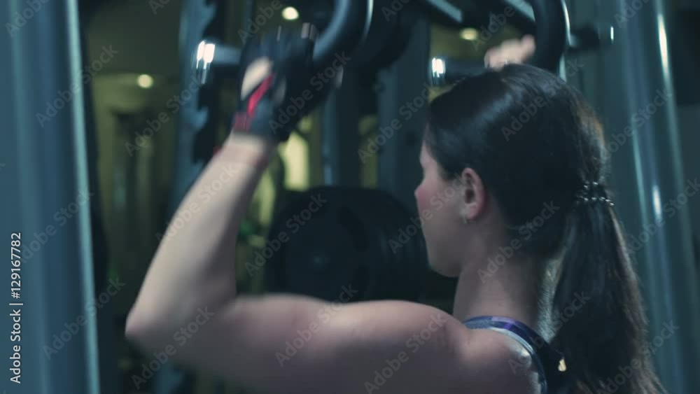Brunette strong fitness sexy woman doing exercise in a gym Brunette strong fitness sexy woman doing exercise in a gym
