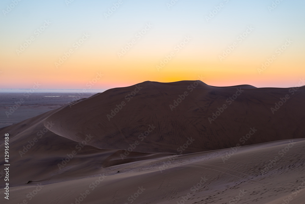Colorful sunset over the Namib desert, Namibia, Africa. Scenic sand dunes in backlight in the Namib Naukluft National Park, Swakopmund. Colorful sunset over the Namib desert, Namibia, Africa. Scenic sand dunes in backlight in the Namib Naukluft National Park, Swakopmund.